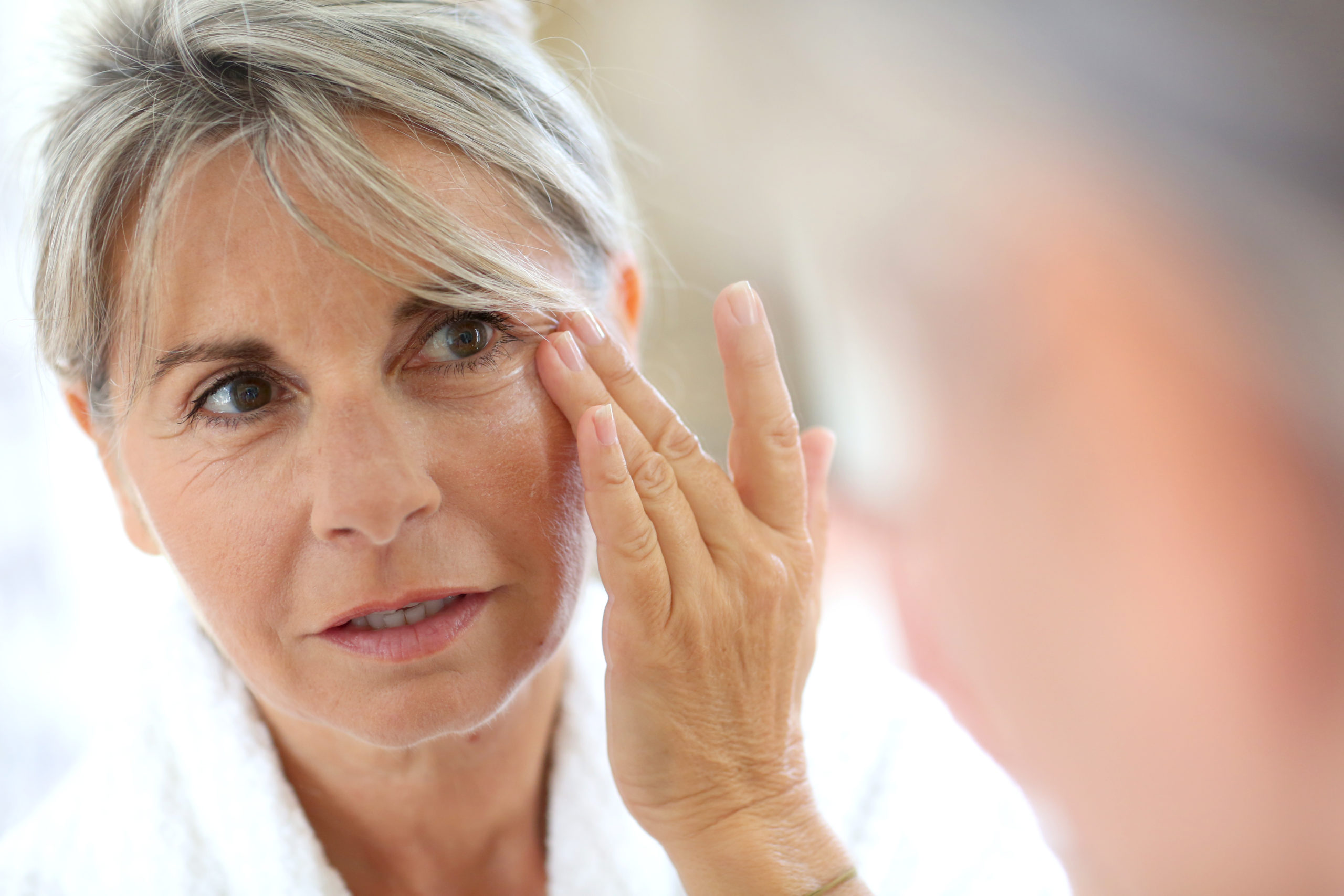 Senior woman applying anti-wrinkles cream - Facial Rejuvenation